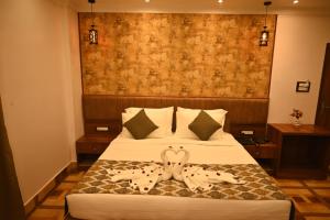 Una habitación de hotel con una cama con dos corazones. en Swet Palash Resort, en Purulia