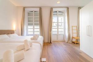 Duas camas num quarto branco com duas janelas em LovelyLoft Rafael 3º em Alicante