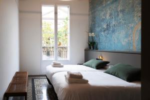 two beds in a room with a window at Hostal Porxos Garden in Barcelona