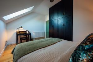 1 dormitorio con 1 cama grande y escritorio en Carpathian Loft with Private Parking, en Odorheiu Secuiesc