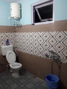 La salle de bains est pourvue de toilettes et d'une fenêtre. dans l'établissement Hateshwari Guest House, à Shimla