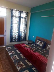 - une chambre avec un grand lit aux murs bleus dans l'établissement Hateshwari Guest House, à Shimla