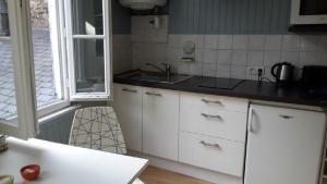 a kitchen with white cabinets and a sink at Le studio de St-Sauveur in Dinan +11 photos