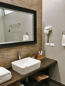a bathroom with a white sink and a mirror at Mahi Mahi Dive Resort in Zamboanguita