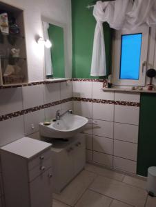 ein Bad mit einem Waschbecken und einem Spiegel in der Unterkunft Thüringer Pforte in Gorsleben