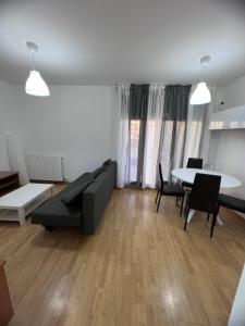 a living room with a couch and a table at Apartamento en Sabiñánigo para grupos con amplia y soleada terraza in Huesca