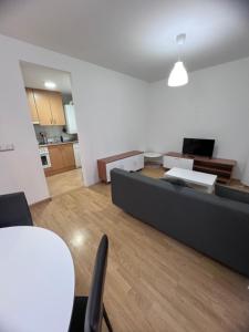 uma sala de estar com um sofá e uma mesa em Apartamento en Sabiñánigo para grupos con amplia y soleada terraza em Huesca
