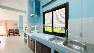 a kitchen with a sink and a large window at Happy Home Villa 1 in Amphoe Koksamui