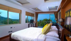 a bedroom with a bed with a view of the mountains at Yupa Penthouse in Amphoe Koksamui