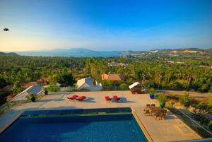 een uitzicht over een zwembad met stoelen en tafels bij Yupa Penthouse in Nathon Bay