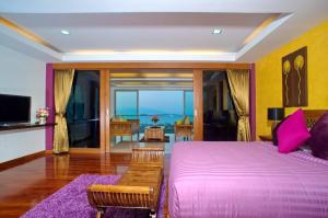 a bedroom with a large bed and a view of the ocean at Yupa Penthouse in Amphoe Koksamui