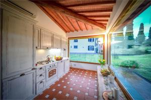 eine Küche mit einem Waschbecken und einem großen Fenster in der Unterkunft Borgo Spedaletto 5 - Dolcevita Holiday in Grassina