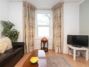 un soggiorno con divano nero e finestra di Pass the Keys Characterful Victorian Home Near Central London a Londra