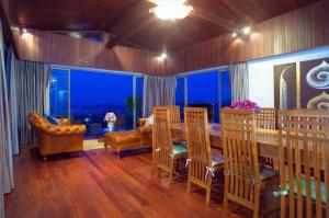 a living room with a table and chairs and a couch at Yupa Penthouse in Amphoe Koh Samui