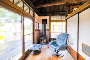 een woonkamer met een stoel en een fornuis bij しまなみ宿Gyoku in Imabari
