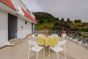 a table with white chairs and a yellow table cloth at 4Bed Luxe Villa with Breakfast l WiFi in Ooty