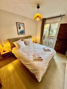 Un dormitorio con una cama grande con dos toallas encima. en AURON 2P NEUF - Le Mont d'Auron, en Auron