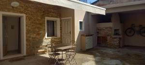 eine Terrasse mit Stühlen, einem Tisch und einem Gebäude in der Unterkunft Titina's House in Tertenìa