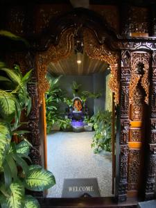 a room with plants and a welcome sign in a mirror at Villa Mabuk in Legian