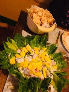 une salade avec des mangues et un bol de chips sur une table dans l'établissement Hotel Miami, à Anurâdhapura