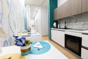 a kitchen with white cabinets and a blue at Enchanting Suites Salerno in Salerno