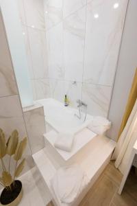 ein weißes Badezimmer mit einer Badewanne und einem Waschbecken in der Unterkunft Enchanting Suites Salerno in Salerno