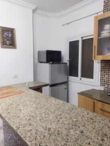 a kitchen with a refrigerator and a counter top at Hurghada City Apartment1 in Hurghada