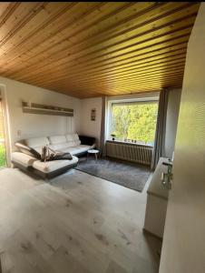 HageにあるFerienhaus Meerwehのソファと窓のあるリビングルーム