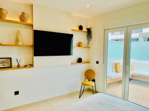 a bedroom with a flat screen tv on a wall at Lantia Rooftop House in Arrecife