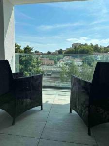 a balcony with two chairs and a view of a city at Wohnung Neubau in Schaffhausen in Schaffhausen