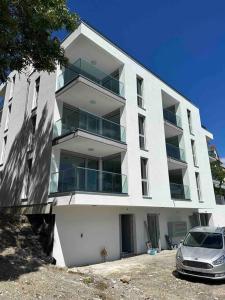 un edificio blanco con un coche aparcado delante de él en Wohnung Neubau in Schaffhausen, en Schaffhausen