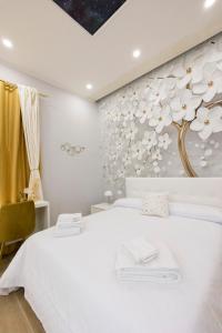 ein Schlafzimmer mit einem weißen Bett und einem Baumbild in der Unterkunft Enchanting Suites Salerno in Salerno