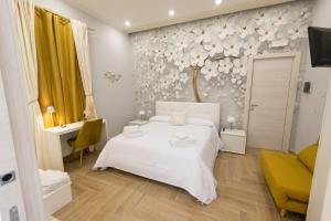 ein Schlafzimmer mit einem weißen Bett und einem Baum an der Wand in der Unterkunft Enchanting Suites Salerno in Salerno