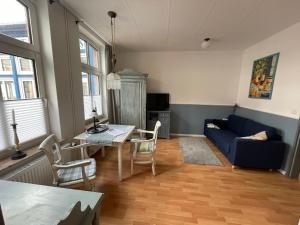 a living room with a blue couch and a table at Aparthotel Domizil in Borkum