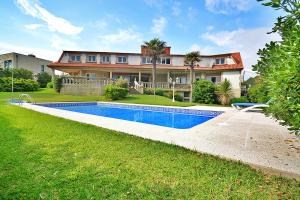 ein Haus mit einem Pool vor einem Haus in der Unterkunft Villa Ultreya in Sanxenxo