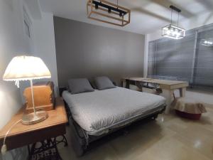 a bedroom with a bed and a desk and a lamp at Eaux Bulles Azur in Cagnes-sur-Mer