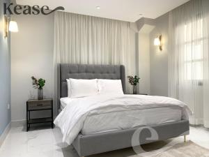 una camera da letto con un grande letto con lenzuola e cuscini bianchi di Kease Yasmin A-3 Royal touch AG44 a Riyad