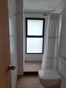 a bathroom with a toilet and a window at Cabaña nórdica en la naturaleza in Punta Ballena