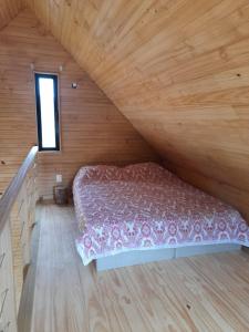 a bedroom with a bed in a wooden room at Cabaña nórdica en la naturaleza in Punta Ballena