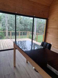 a large wooden table in a room with a large window at Cabaña nórdica en la naturaleza in Punta Ballena