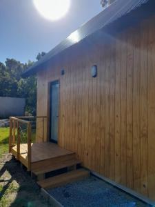 - un petit bâtiment en bois avec une terrasse couverte et des escaliers dans l'établissement Cabaña nórdica en la naturaleza, à Punta Ballena