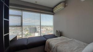 a bedroom with a bed and a large window at Ruby Apartment #23 in Yogyakarta