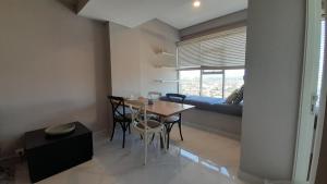 a dining room with a table and chairs and a couch at Ruby Apartment #23 in Yogyakarta