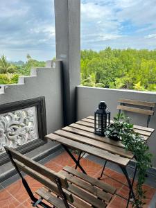 - Balcón con mesa de madera y 2 sillas en Rhu Dormitory, en Tanjung Rhu