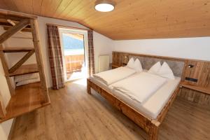 ein Schlafzimmer mit einem Bett und einem großen Fenster in der Unterkunft Hubergut Appartements in Radstadt