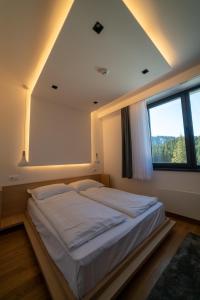 a bedroom with a large bed with a window at Lux apartment Zlatni Javor Jahorina in Jahorina +37 photos