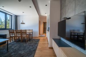 a dining room and living room with a large flat screen tv at Lux apartment Zlatni Javor Jahorina in Jahorina