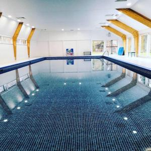 a large swimming pool with a blue tile floor at Het mooiste vakantiehuisje in Durbuy in Durbuy