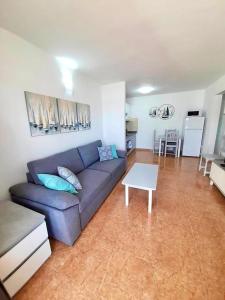 a living room with a blue couch and a table at Apartamento Lory-Puerto del Carmen in Puerto del Carmen