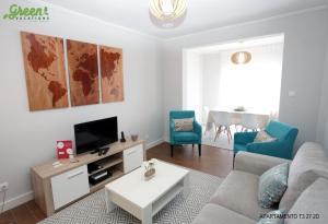 a living room with a couch and a tv at Apartamento Mãe de Deus in Ponta Delgada